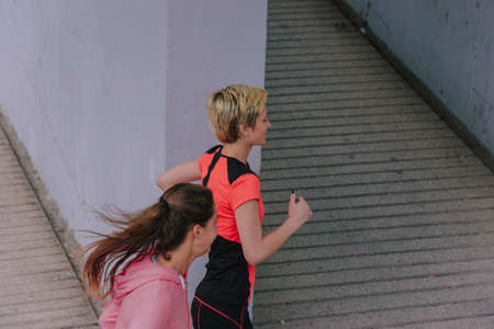 Young healthy female runners during an urban workout routine