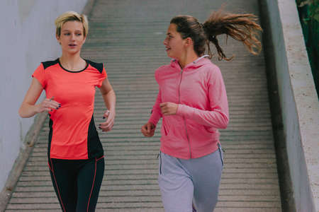 Young healthy female ahtletes exercising with a run in the city