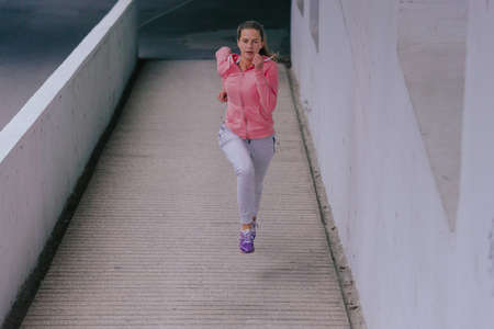 Attractive athletic girl exercising in an urban area during daytime