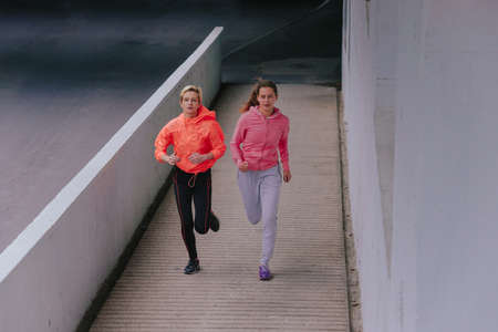 Young healthy female runners during an urban workout routineの写真素材