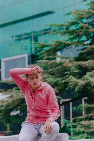 Closeup shot of young woman listening to music in a downtownの写真素材