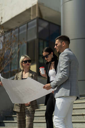 Three business people are having aa conversation about the plan