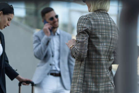 Two businesswomen are having a business conversation aboit the company while the businessman is...