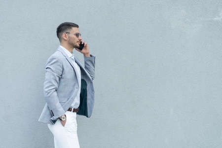 Handsome businessman is havinga  phonce on a claer backgroundの写真素材