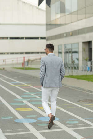 Urban businessman is walking in front of the companyの写真素材