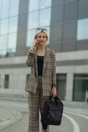 Businesswoman is smiling while talking on her phone with her partnersの写真素材