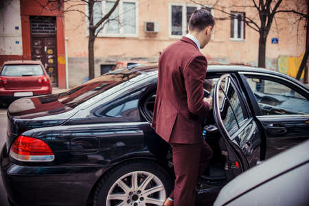 Businessman standing next to his car and about to get inの写真素材