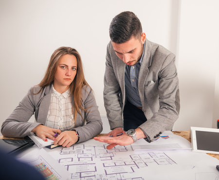 Male and female business sitting on a business table looking formal while discussing their next project.の写真素材
