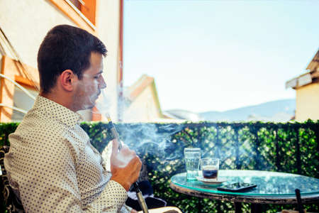 Man with hookah relaxing on beatiful summer dayの写真素材