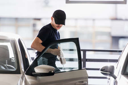 A young robber is looking nervous while entering in the stolen car