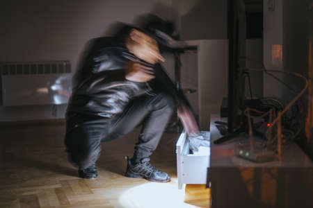 Young burglar breaking in the flat and stealing money