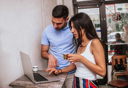 Portrait of affectionate couple in stylish clothes having coffee in cafeの写真素材