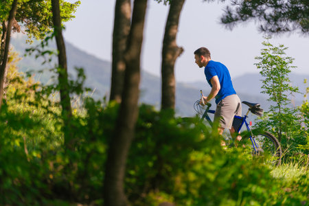 Adventurous mountain biker riding his bike fast through the woods ( forest ) while enjoying the green nature.の写真素材