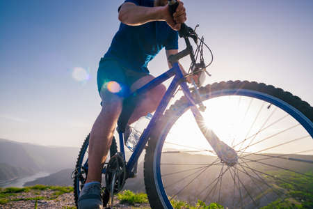 Close up photo from a mountain biker riding his bike ( bicycle) on rough rocky terrain on top of a...