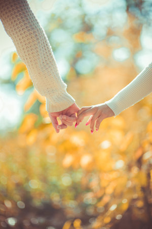 Attractive modern couple is holding hands outdoors on a sunny dayの写真素材