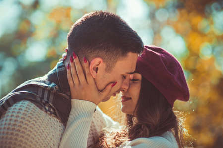Handsome couple is enjoying the beautiful weather in the wood and trying to kissの写真素材