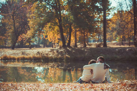 Charming couple in love sitting od the grass in the park and huggingの写真素材