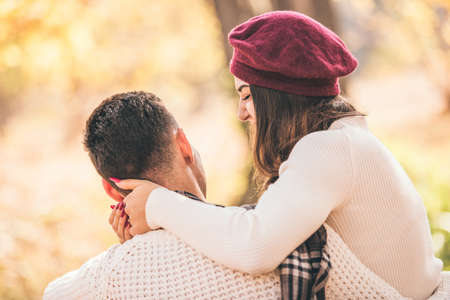 Modern couple is outdoors, enjoying the autumn day and the sun in the park