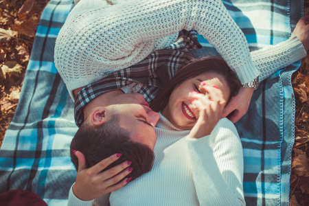 Attractive couple is lying in the park and having fun togetherの写真素材