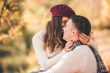 Careless couple standing next to beautiful tree and hugging each otherの写真素材