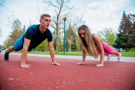 Couple stretching muscles  in park. Athlete do workout outdoors. Sport, yoga, pilates, fitness,...