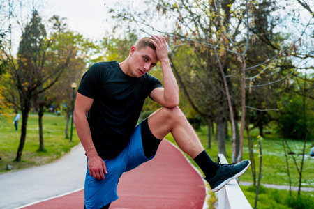 Young athlete man streching in the park outdoor. male runner warm up ready for jogging on the road...
