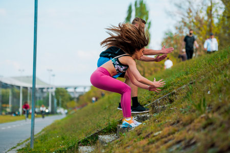 Fitness running couple jogging on athletics stadium track open air during hot summer day....