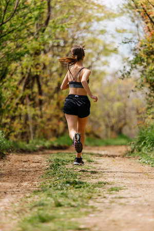 Fit woman jogging exercising running cardio workout focused female runner endurance trainingの写真素材