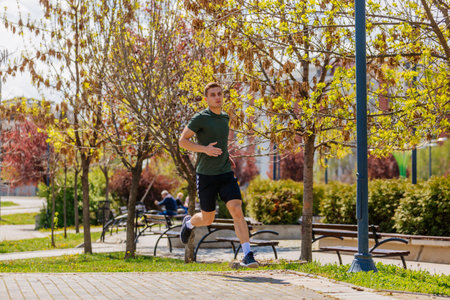 Sport man running. Portrait of runner man jogging in park. Sport workout outdoor. Athlete training...