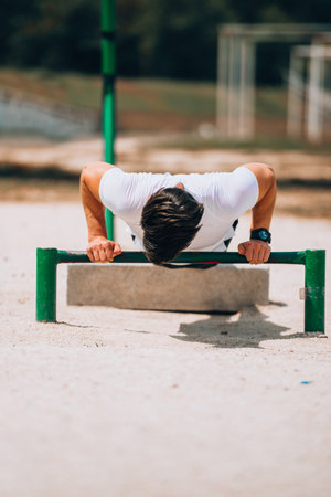 Athlete working out chest muscles strength training outdoors
