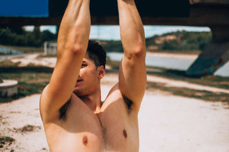 A young male model posing his muscles while trainingの写真素材