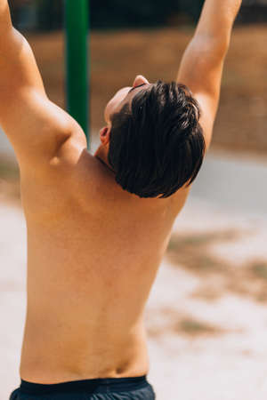 A young male model posing his muscles while training