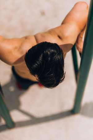 Portrait of a confident strong shirtless male bodybuilder preapiring for exercising
