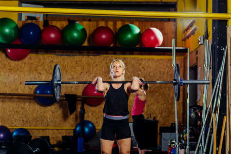 Beautiful sports fitness girl with a barbell