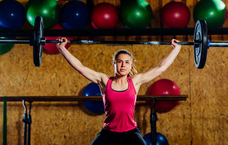 Beautiful girl having workout with barbell