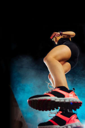 Sporty girl jumping over some boxes in a cross-training gymの写真素材