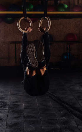 Man at functional fitness training in gym doing sport on rings