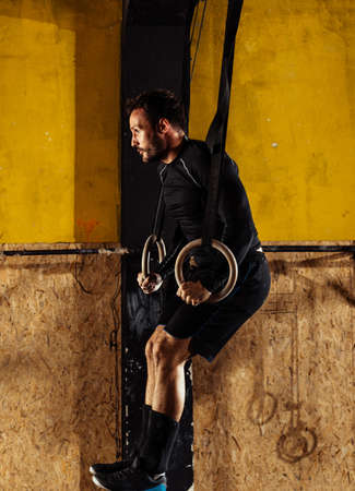Concept: power, strength, healthy lifestyle, sport. Powerful attractive muscular man at CrossFit gym