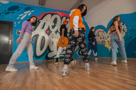 Young dancers in colorful wear having fun dancing hip-hop, enjoy being active. lifestyle, youth...
