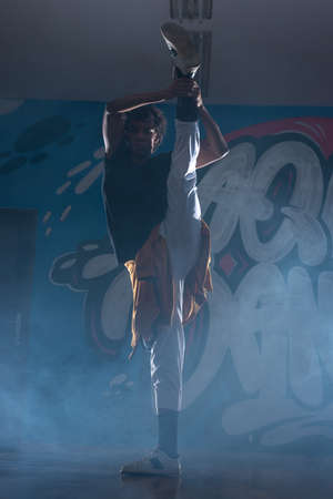Young man break dancing in club with lights and smoke.の写真素材