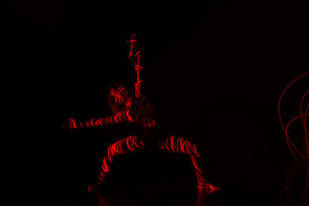 Ballet dancer dancing in front of and red light while expressing the hell with her magnificent dance...