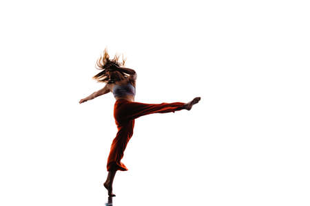 Graceful slender dancer performing a dance routine in the studio