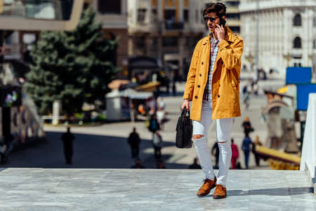 Fashion male businessman with cellphone going in his office