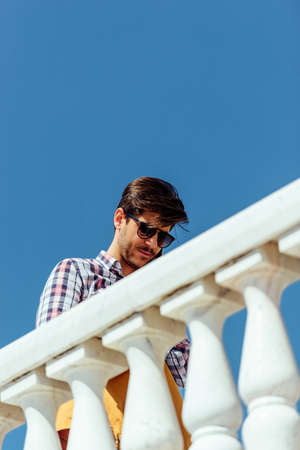 Young urban businessman professional on smartphone walking in street while holding tabletの写真素材