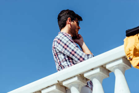 Fashionable businessman doing call conversation at urban place near officeの写真素材