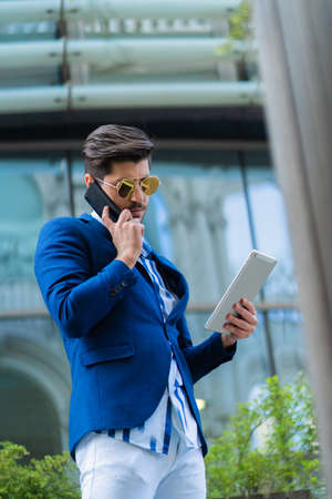 Businessman is talking to his partners on the phone while thinking about his work plans and ideas for his companyの写真素材