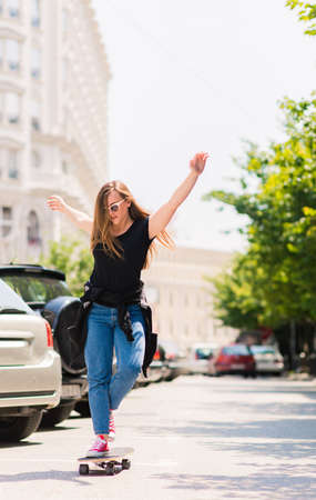 Urban girl having fun with skate board on a sunny day