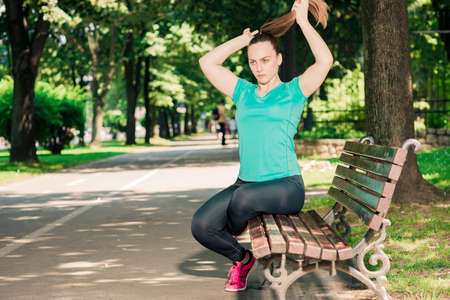 Fitness girl and her rest during jogging in parkの写真素材