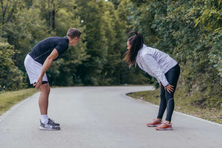 Male and female athletes preparing for a marathon, run, workout. Healthy lifestyle concept.の写真素材