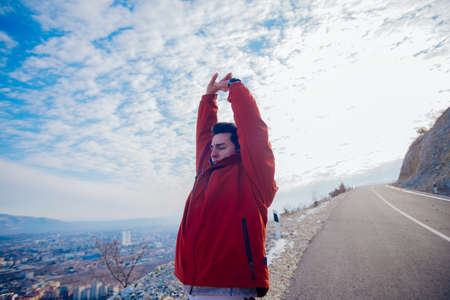 Strong male in his 20s stretching in the morning at winter while looking at his hometown in the valley.の写真素材